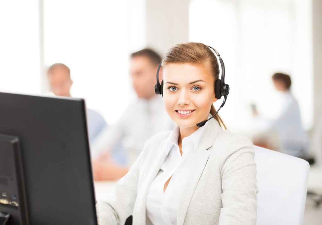 friendly female helpline operator with headphones in call centre